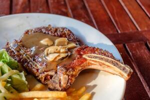 grillé porc travers de porc steak bien joué avec français frites et légume photo