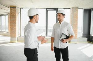 deux spécialistes inspecter commercial, industriel bâtiment construction placer. réel biens projet avec civil ingénieur photo