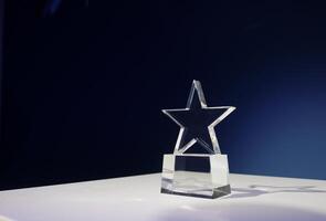 en forme d'étoile prix fabriqué de verre sur une blanc table avec une projecteur sur il et copie espace photo