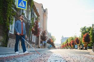 aveugle homme. gens avec invalidité, handicapé la personne et tous les jours vie. visuellement altéré homme avec en marchant bâton. photo