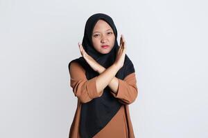 photo de sur de soi asiatique femme dans hijab traversée sa bras demander vous à Arrêtez harcèlement jolie isolé sur blanc Contexte