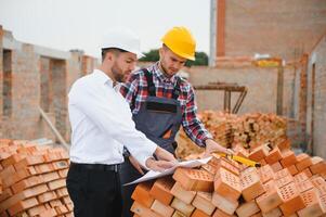 ingénieur architecte avec difficile chapeau et sécurité gilet travail ensemble dans équipe sur Majeur construction site photo