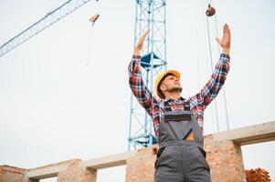 communicant avec grue gars. construction ouvrier dans uniforme et sécurité équipement avoir emploi sur bâtiment. photo