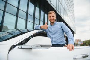 Beau Jeune homme d'affaire permanent près le sien voiture en plein air. photo