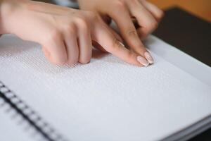 aveugle femme lis livre écrit dans braille. proche en haut doigt toucher à braille code photo