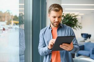 une pigiste homme travaux avec une tablette dans une travail encadrement Bureau photo