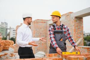 de construction ingénieur et contremaître ouvrier discuter, plan travail pour le en plein air bâtiment construction site photo