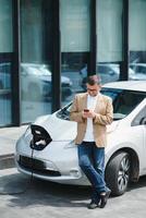 une homme d'affaire des charges un électrique voiture photo