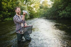 pêche. pêcheur et truite. pêcheur sur sauvage rivière. photo