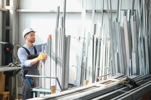 professionnel en tissu ouvrier. métal En traitement plante. une ouvrier à une métal profil entrepôt. photo