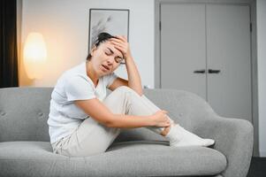 Jeune femme Souffrance de abdominal douleur à maison. gynécologie concept photo