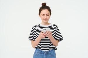 La technologie et mode de vie. Jeune femme permanent plus de blanc Contexte avec téléphone intelligent photo