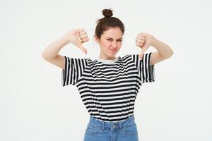 portrait de déçu, Jeune moderne femme, étudiant spectacles les pouces bas, n'aime pas qch, désapprouve, des stands plus de blanc Contexte photo