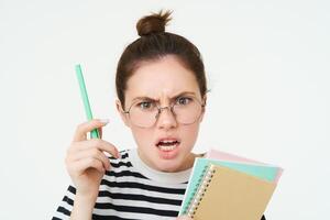 proche en haut portrait de femme en criant, portant lunettes, tremblement stylo et en portant formalités administratives, des cahiers, prof argumentant, réprimande quelqu'un, permanent plus de blanc Contexte photo