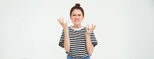 portrait de en colère femme en criant et tremblement mains, perdant sa caractère, argumentant, permanent plus de blanc Contexte photo