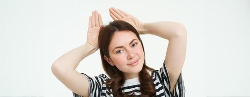 image de magnifique Jeune femme, posant avec animal oreilles sur tête et souriant, fabrication mignonne affronter, blanc Contexte photo