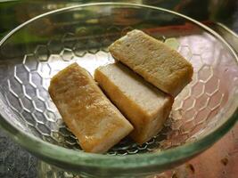frit Tofu délicieux dans clair bol sur cuisine Contexte. photo