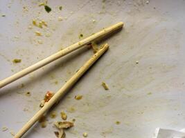 sale vide assiettes après manger et baguettes après en mangeant sur plaque. photo