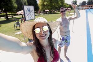 Jeune aimant couple à côté de le bassin prend une selfie photo