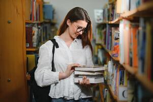 éducation, haute école, université, apprentissage et gens concept. souriant étudiant fille en train de lire livre photo