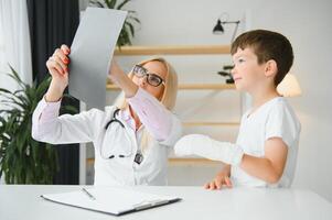 pédiatre médecin bandage enfant bras. cassé bras dans une garçon. photo