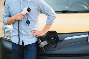 homme mise en charge le sien électrique voiture à charge gare. photo