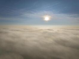 Soleil en hausse plus de une dense couche de brouillard photo
