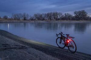 gravier bicyclette sur une rive de une congelé lac, hiver crépuscule dans nord Colorado photo