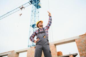 communicant avec grue gars. construction ouvrier dans uniforme et sécurité équipement avoir emploi sur bâtiment. photo