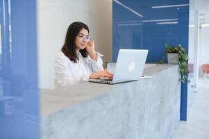 amical Jeune femme derrière le accueil bureau administrateur photo