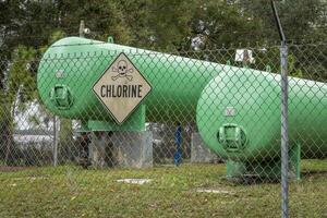 industriel chlore gaz réservoirs derrière une clôture avec une avertissement signe photo