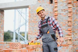 Jaune coloré difficile chapeau. Jeune homme travail dans uniforme à construction à jour. photo