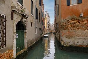 typique étroit des rues et canaux entre coloré et minable Maisons dans Venise, Italie. historique architecture dans Venise, garé bateaux sur le canaux. photo