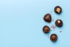 différent sortes de des chocolats sur coloré table fermer. Haut vue et plat allonger avec copie espace photo