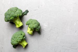 Haut vue Frais vert brocoli légume sur coloré Contexte. brocoli chou tête en bonne santé ou végétarien nourriture concept. plat poser. copie espace photo