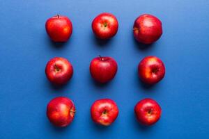 beaucoup rouge pommes sur coloré arrière-plan, Haut voir. l'automne modèle avec Frais Pomme au dessus vue photo