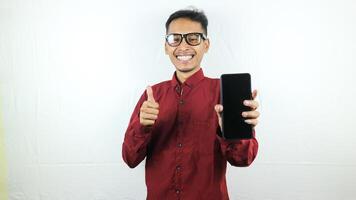 portrait de asiatique homme en portant mobile téléphone avec visage expression souriant à caméra. photo