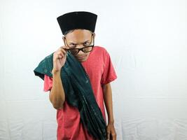 marrant expression content asiatique homme portant sarong, des lunettes et casquette photo