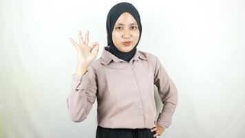 Jeune asiatique musulman femme montrant D'accord signe avec les doigts isolé sur blanc Contexte photo
