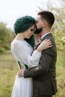 une barbu jeune marié et une fille avec vert cheveux sont en marchant photo
