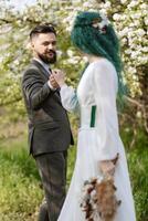 une barbu jeune marié et une fille avec vert cheveux Danse et tournoiement photo