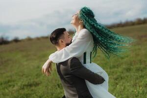 une barbu jeune marié et une fille avec vert cheveux Danse et tournoiement photo
