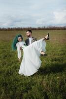 une barbu jeune marié et une fille avec vert cheveux Danse et tournoiement photo