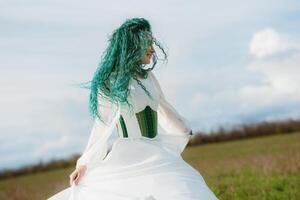 Jeune fille la mariée avec vert cheveux dans une nationale robe photo