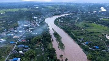 vue aérienne de la rivière ping à travers les rizières et les villages ruraux au coucher du soleil. vues des villages de chiang mai et de la rivière ping depuis un drone. photo