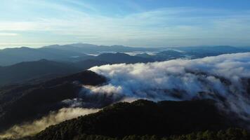 aérien vue plus de le montagnes avec mer de brouillard pendant Matin lever du soleil dans bleu ciel. mer de des nuages autour Montagne pics à lever du soleil. invisible Voyage dans nord Thaïlande photo