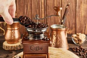 verse café des haricots dans ancien café broyeur, café brasseur et cuivre tasse sur en bois Contexte photo