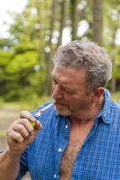 portrait de bûcheron qui lumières une cigarette tandis que prise une Pause photo