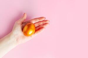 la femme tient un oeuf d'or de pâques brillant dans sa main. photo