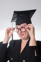 mature femme avec des lunettes et l'obtention du diplôme casquette photo